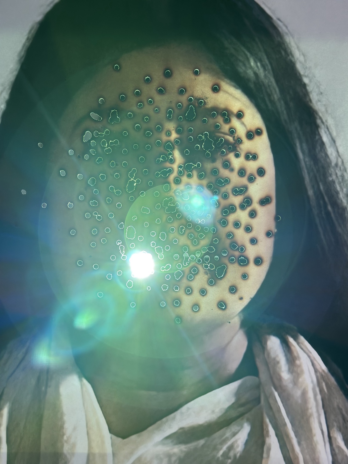 A face overlaid with points of light, a residue image titled Luminous Pause